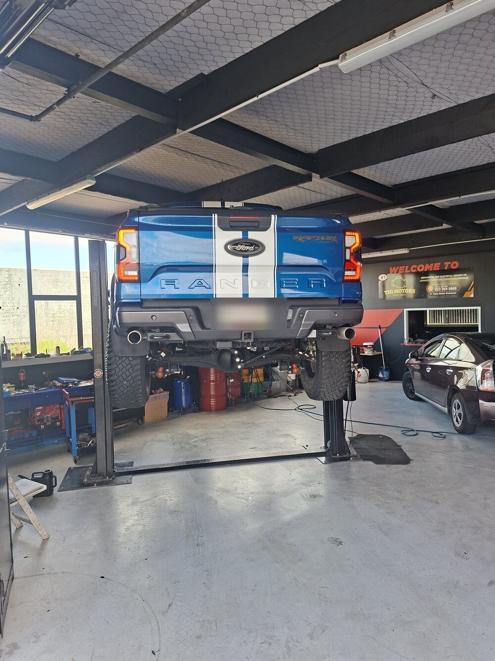Ford Ranger Raptor raised on a two-post hoist inside the THI Motors workshop in Otahuhu